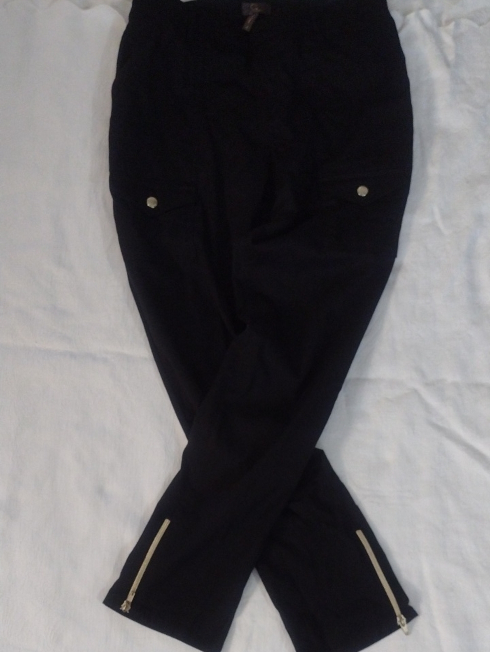 Sleek Blackcropped scrub pants with front cargo pockets. Ankle zippers and gold-